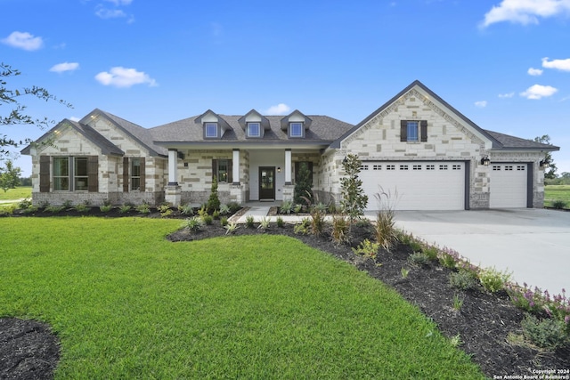 view of front of property featuring a porch, a garage, and a front lawn