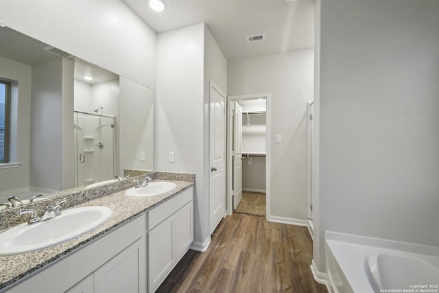 bathroom with separate shower and tub, vanity, and hardwood / wood-style flooring