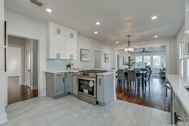 kitchen featuring kitchen peninsula, appliances with stainless steel finishes, ceiling fan, gray cabinets, and hanging light fixtures