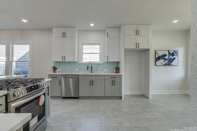 kitchen with backsplash, sink, and appliances with stainless steel finishes