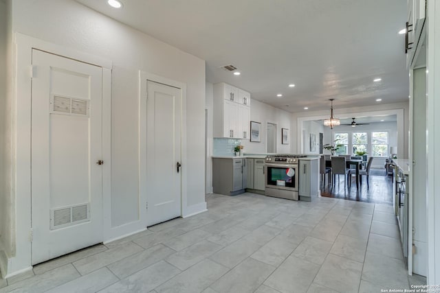 kitchen featuring white cabinetry, stainless steel range, ceiling fan, backsplash, and pendant lighting