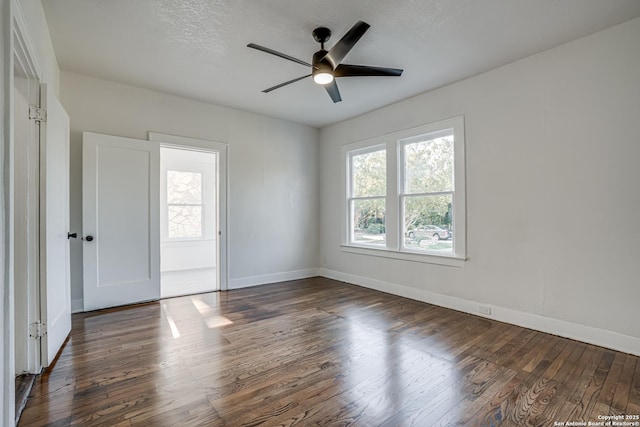 empty room featuring ceiling fan, dark hardwood / wood-style flooring, and a textured ceiling