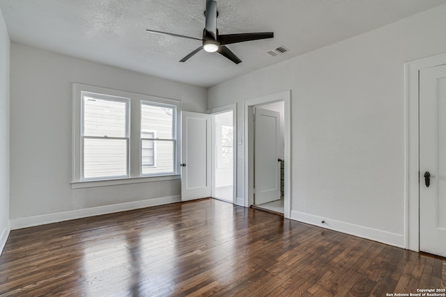 empty room featuring ceiling fan, dark hardwood / wood-style flooring, and a textured ceiling