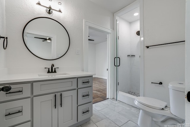 bathroom featuring vanity, toilet, and a shower with shower door