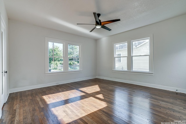 spare room with a textured ceiling, ceiling fan, and dark hardwood / wood-style floors