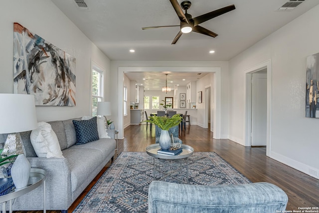 living room featuring ceiling fan with notable chandelier and wood-type flooring