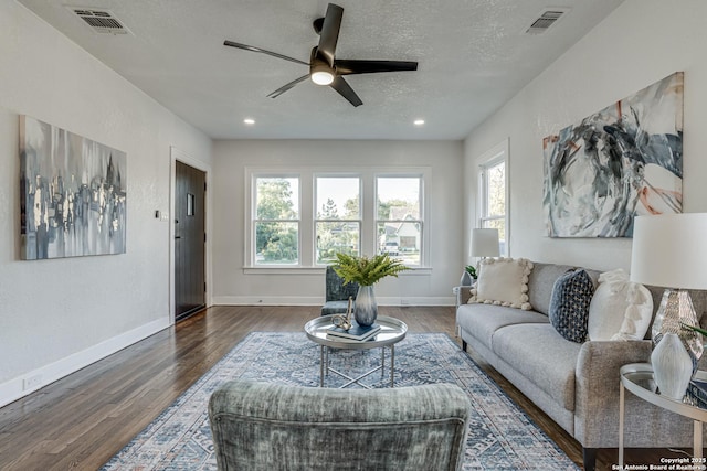 living room with dark hardwood / wood-style floors, ceiling fan, and a wealth of natural light