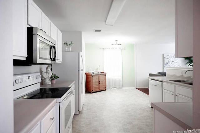 kitchen featuring white cabinetry, white appliances, and sink