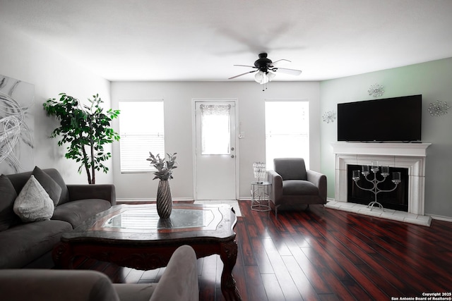 living room featuring a tile fireplace, wood-type flooring, and ceiling fan