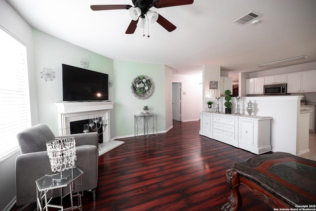 living room with ceiling fan and dark wood-type flooring