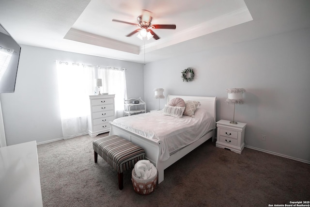 carpeted bedroom with ceiling fan and a tray ceiling