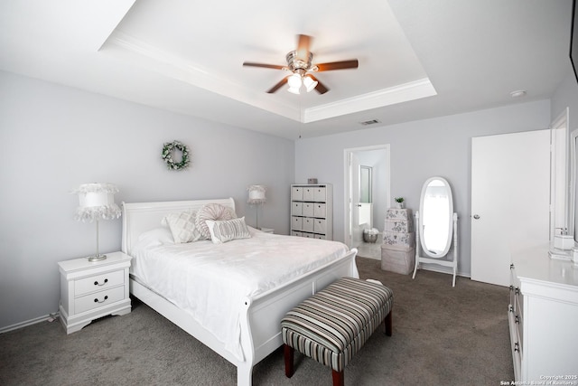 carpeted bedroom with a raised ceiling and ceiling fan