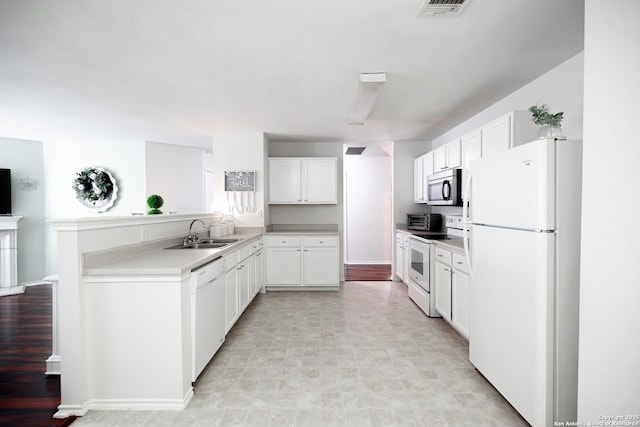 kitchen with sink, white cabinets, and white appliances