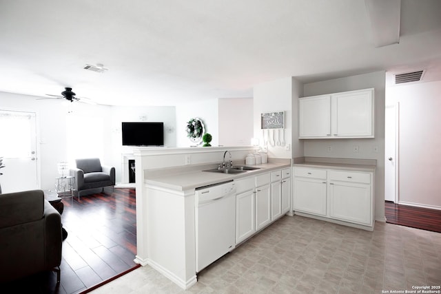 kitchen with kitchen peninsula, white cabinetry, dishwasher, and sink