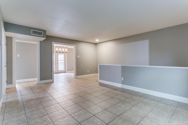 tiled empty room with a chandelier