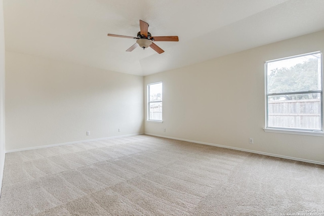 spare room with ceiling fan, lofted ceiling, and light carpet