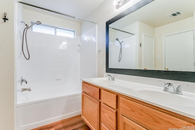 bathroom featuring hardwood / wood-style floors, vanity, and tiled shower / bath