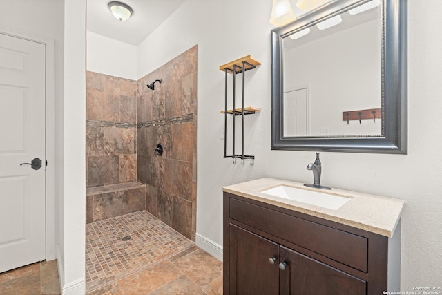 bathroom featuring a tile shower and vanity