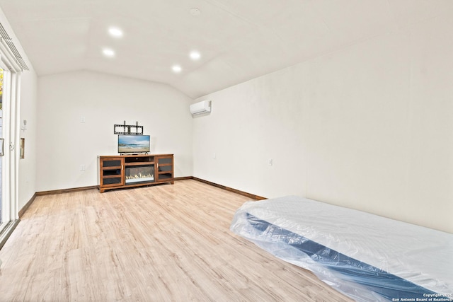 bedroom featuring wood-type flooring, vaulted ceiling, and an AC wall unit