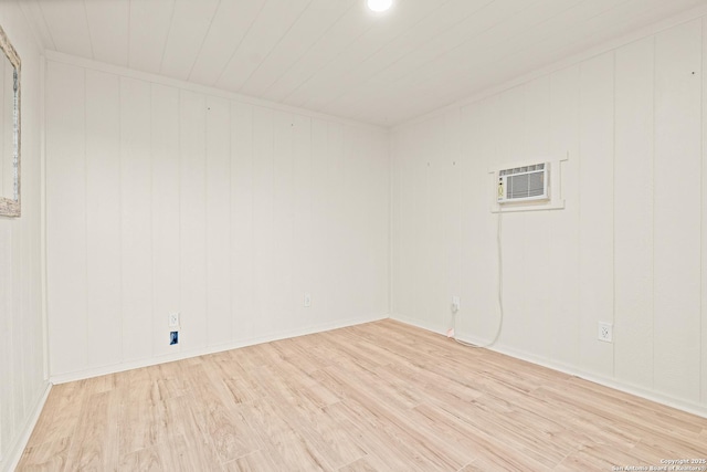 spare room with light hardwood / wood-style flooring and an AC wall unit