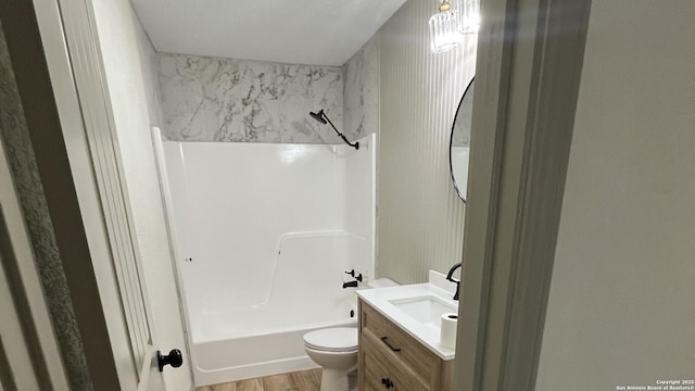 full bathroom featuring hardwood / wood-style floors, vanity, toilet, and  shower combination