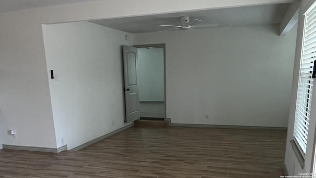 spare room with a wealth of natural light, dark wood-type flooring, and ceiling fan