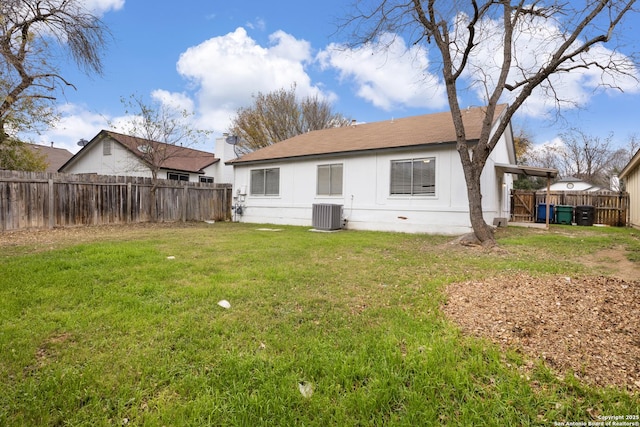 back of property with a yard and central air condition unit