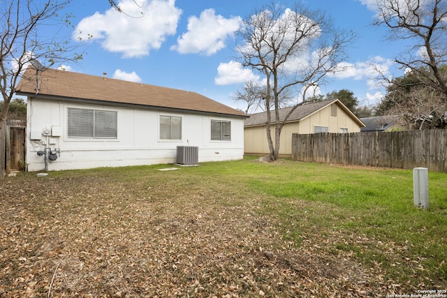 rear view of property with a lawn and central air condition unit