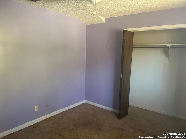 unfurnished bedroom with a closet, carpet, and a textured ceiling