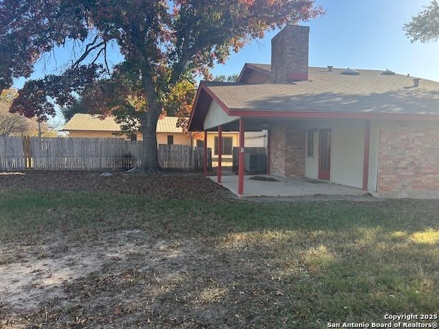 back of house with a patio area and a yard