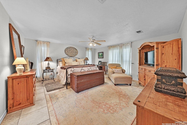 bedroom featuring light tile patterned floors and a textured ceiling