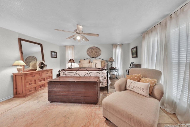 bedroom with ceiling fan and a textured ceiling