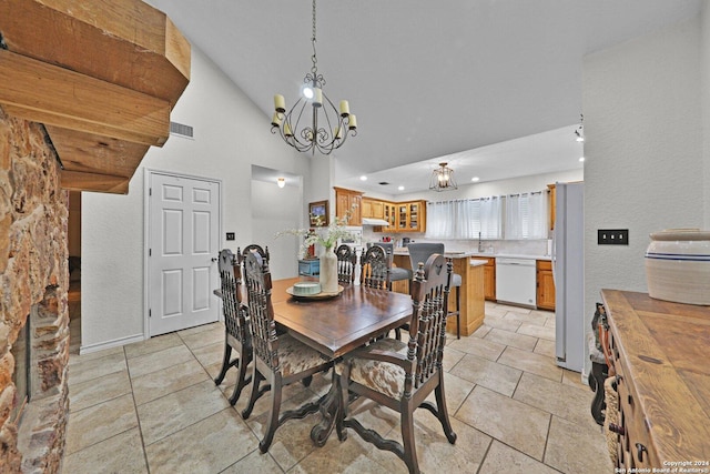 tiled dining area with sink, high vaulted ceiling, and an inviting chandelier