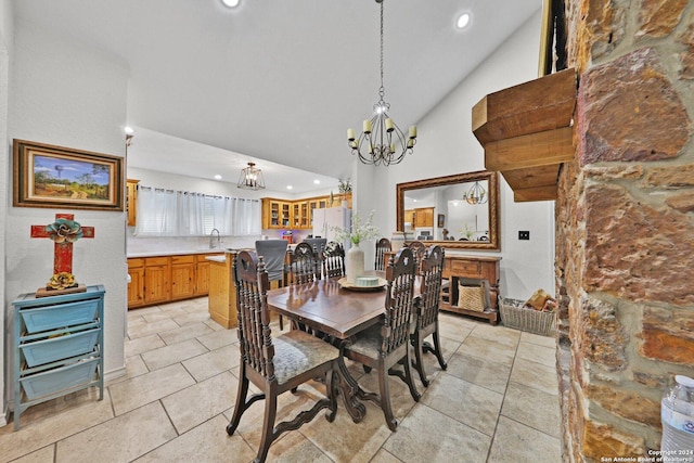 dining area with light tile patterned floors, sink, high vaulted ceiling, and a chandelier