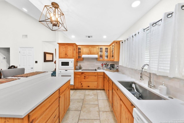 kitchen featuring sink, a notable chandelier, backsplash, pendant lighting, and white appliances