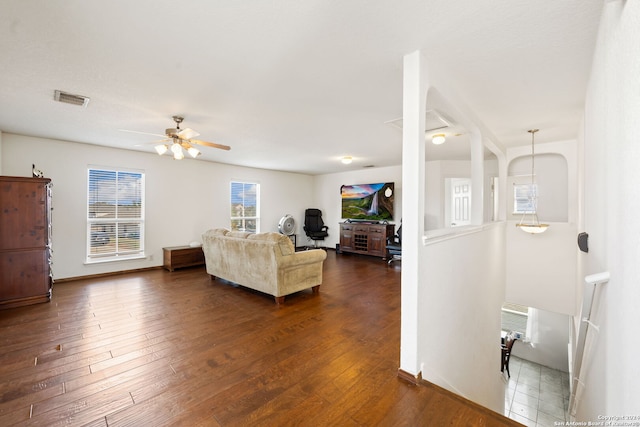 living room featuring ceiling fan and dark hardwood / wood-style floors