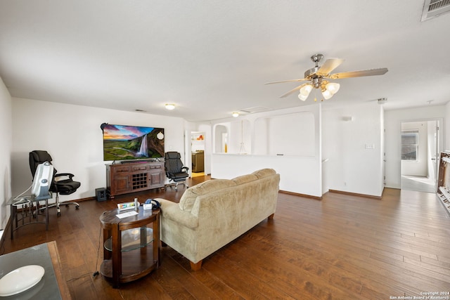 living room featuring ceiling fan and dark wood-type flooring