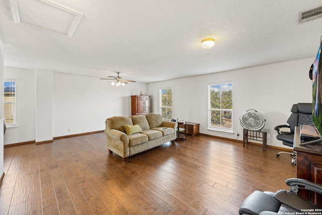 living room featuring a textured ceiling, dark hardwood / wood-style floors, and ceiling fan