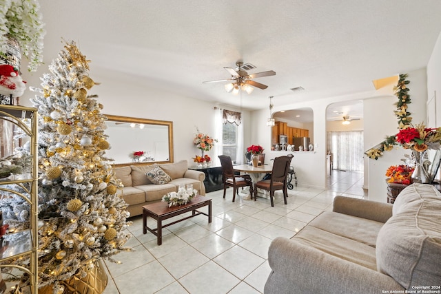 tiled living room with ceiling fan and a textured ceiling