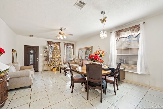 dining space with ceiling fan, light tile patterned floors, and a textured ceiling