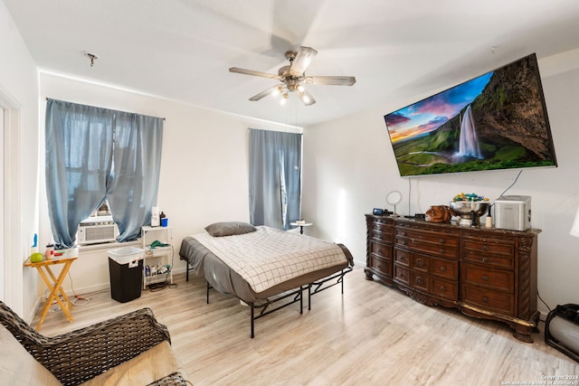 bedroom featuring ceiling fan, cooling unit, and light hardwood / wood-style floors