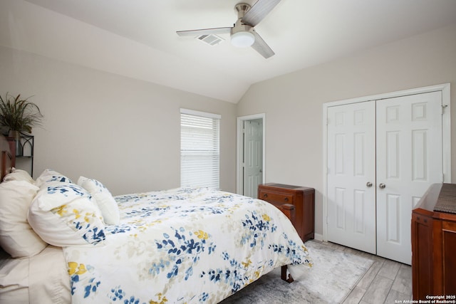 bedroom featuring ceiling fan, a closet, vaulted ceiling, and light wood-type flooring