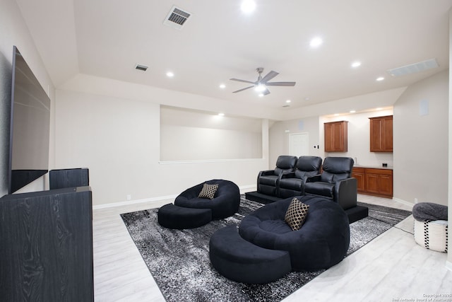 cinema room with light wood-type flooring and ceiling fan