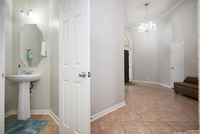 bathroom featuring tile patterned floors, sink, an inviting chandelier, and ornamental molding