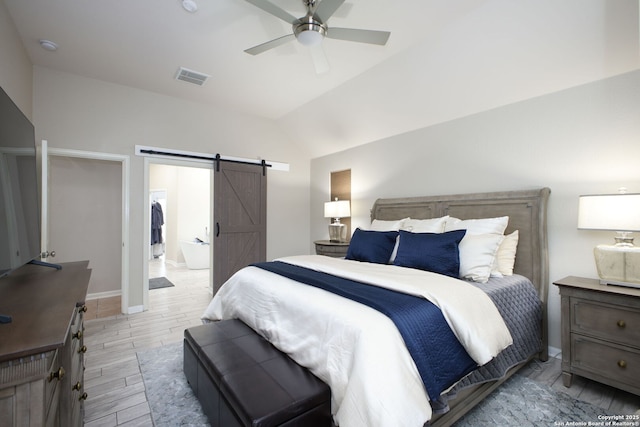 bedroom featuring ceiling fan, a barn door, and vaulted ceiling