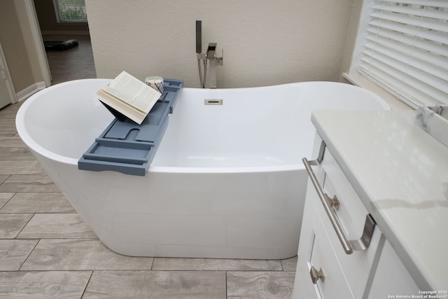 bathroom featuring a washtub and vanity