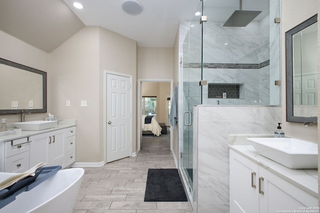 bathroom featuring plus walk in shower, vanity, and vaulted ceiling