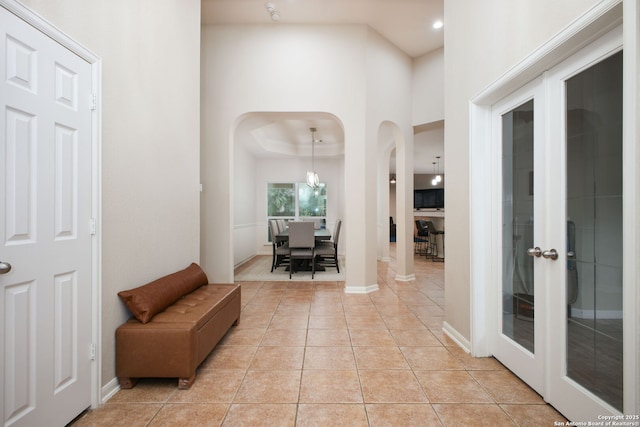 hallway featuring a raised ceiling and light tile patterned floors