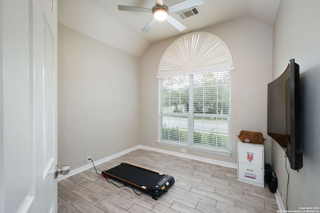 workout room featuring ceiling fan, a healthy amount of sunlight, and vaulted ceiling