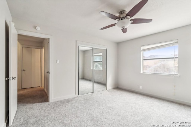 unfurnished bedroom featuring ceiling fan, multiple windows, and a closet